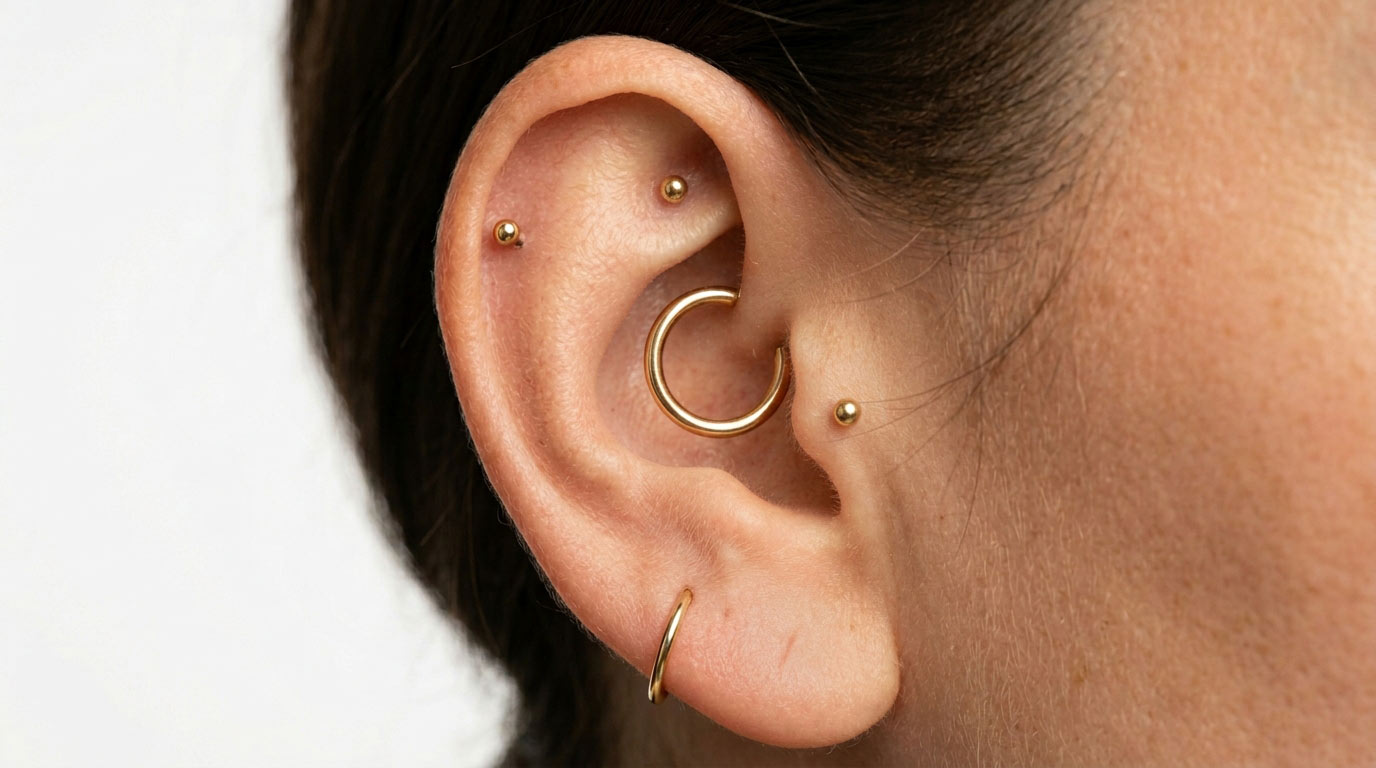 Ear with five piercings — helix, tragus, lobe — piercing healing times guide