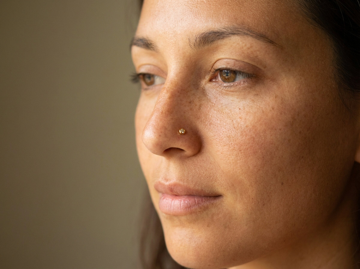 Woman with gold nose ring — double nostril and septum piercing combination 2025 trend