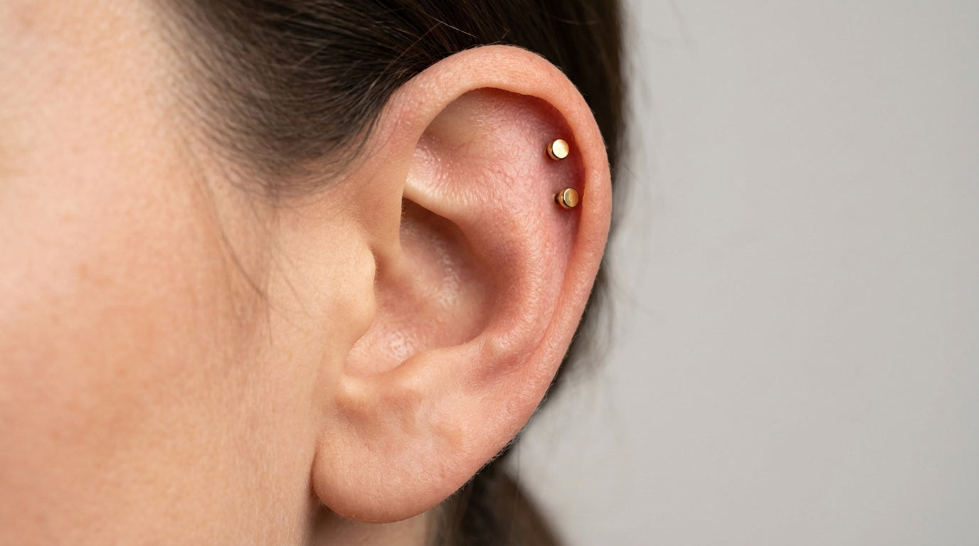 Woman's ear showing helix piercing placement on upper cartilage rim — standard helix and double helix positions