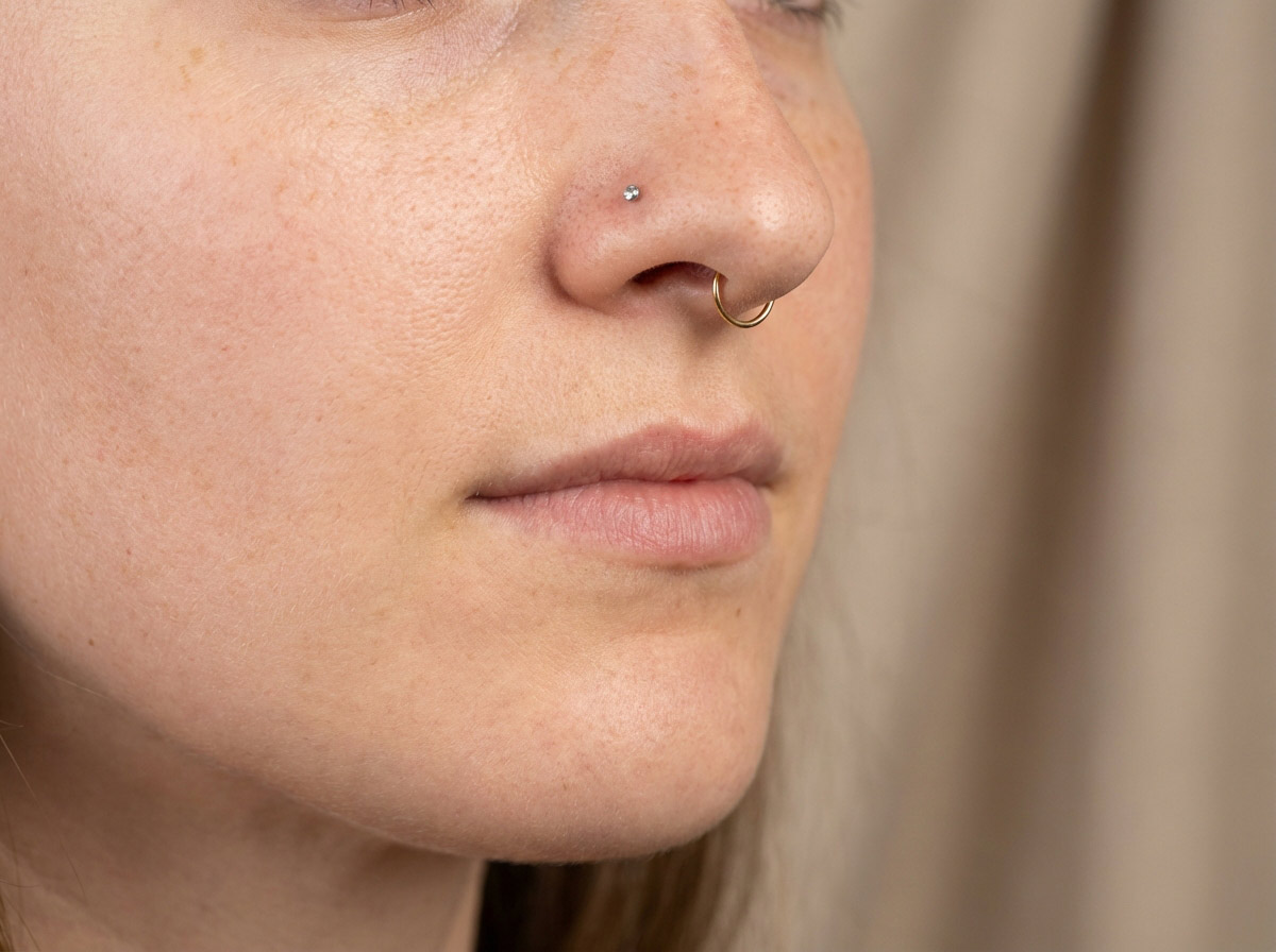 Woman's nose with nostril piercing — showing standard placement on the alar crease